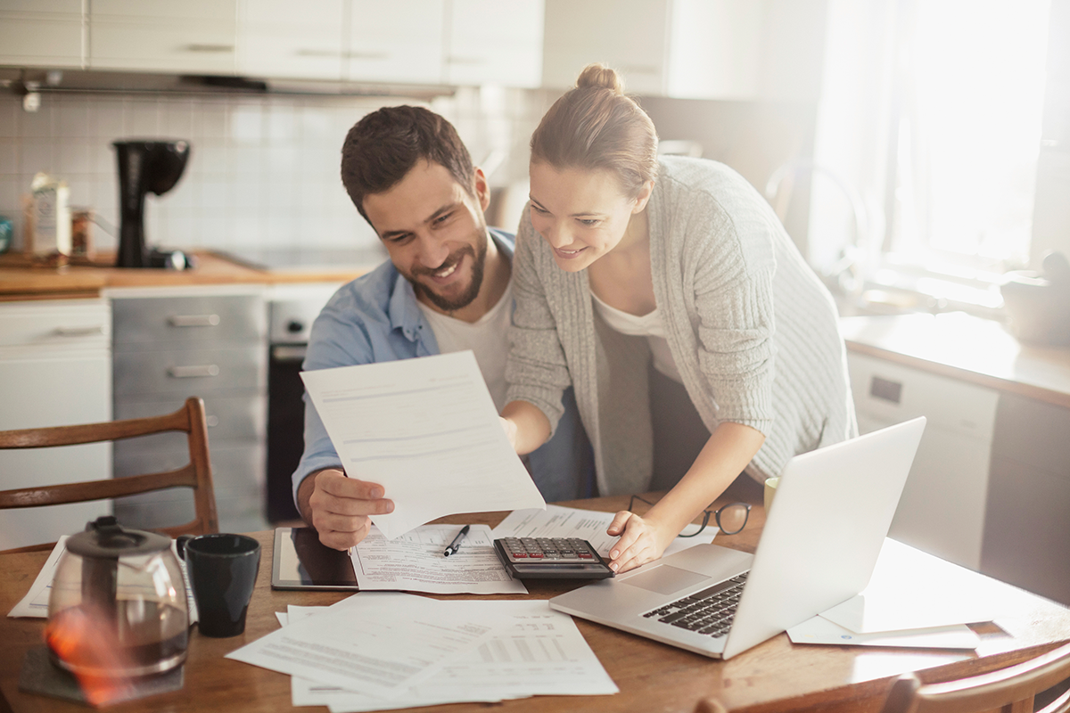 This image of a couple in their home reviewing financial information that can provide them with more information about RRSPs and how to retire comfortably.